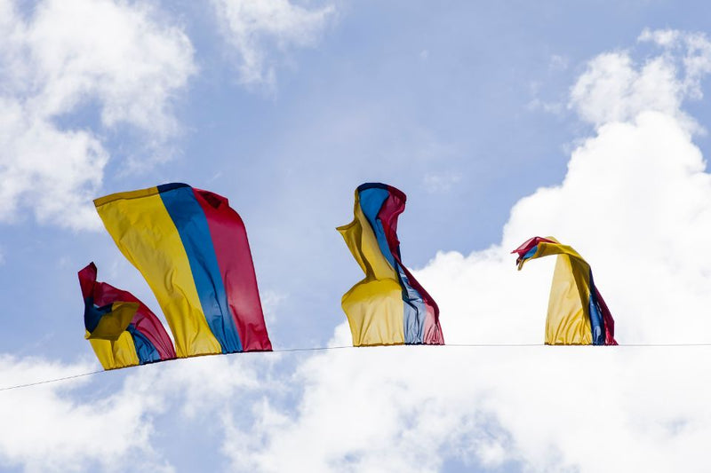Colombianske flagg som vaier mot en blå himmel